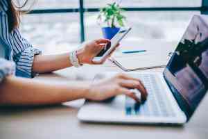 © BullRun - Adobe Stock.com Frau mit Smartphone und Laptop